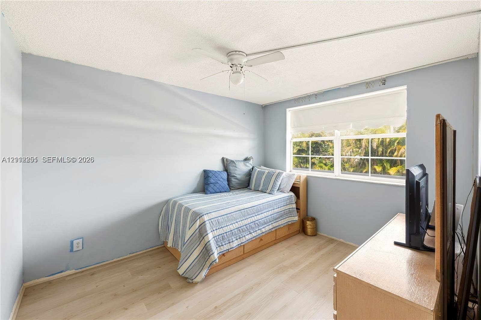 4025 N Federal Highway, #226C, Oakland Park, FL 33308 Room featuring wood-finish flooring, a multi-pane window, and a ceiling-mounted fan with integrated lighting