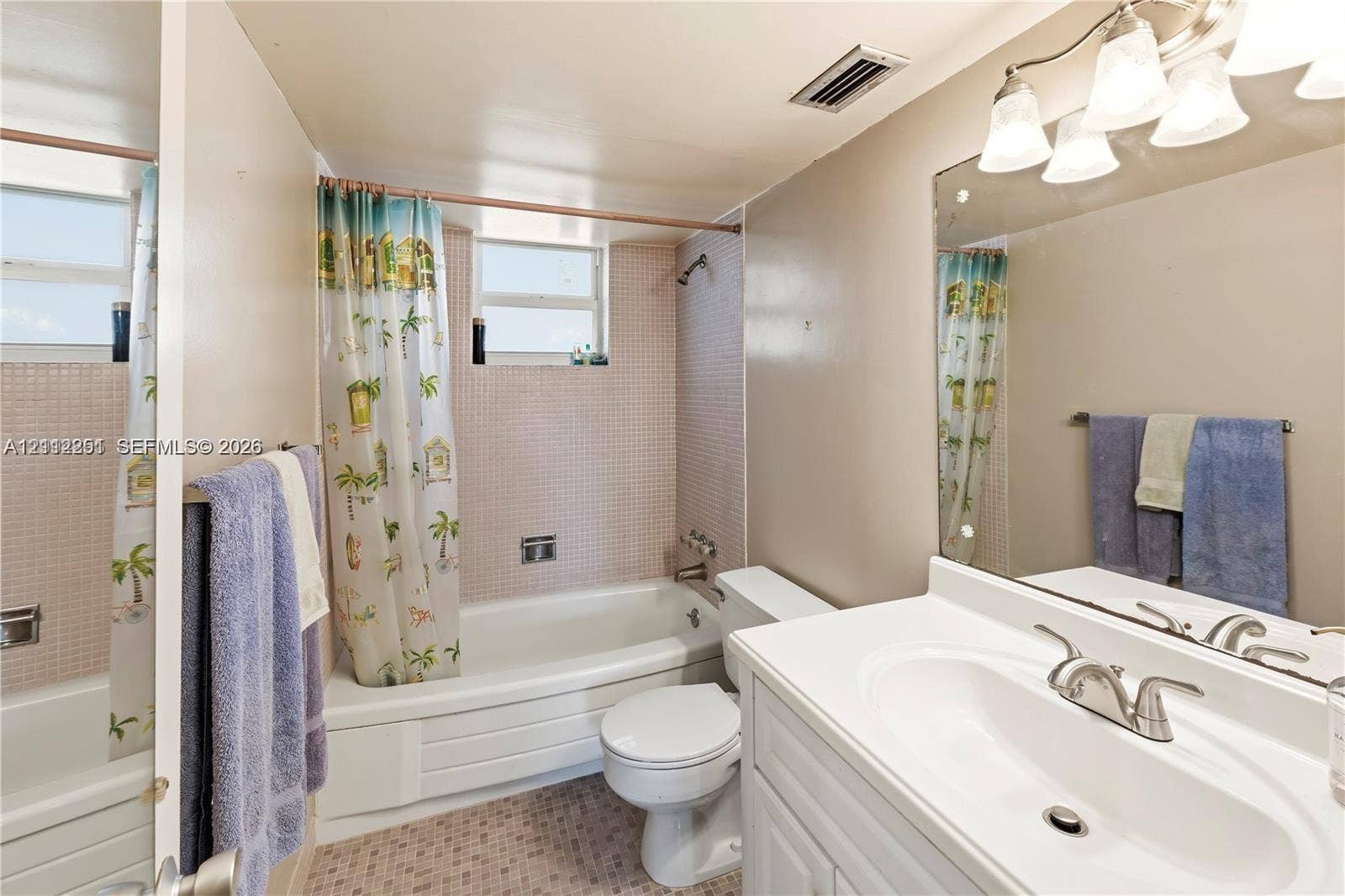 4025 N Federal Highway, #226C, Oakland Park, FL 33308 Bathroom featuring a white vanity with an integrated sink, a large wall-mounted mirror, a tub-shower combination with tile surround, and a tile-finished floor