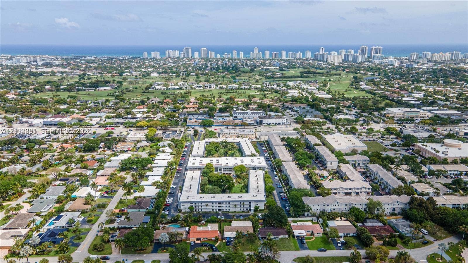4025 N Federal Highway, #226C, Oakland Park, FL 33308 Aerial perspective of a multi-story residential complex featuring a central courtyard with mature landscaping and proximity to the coastline