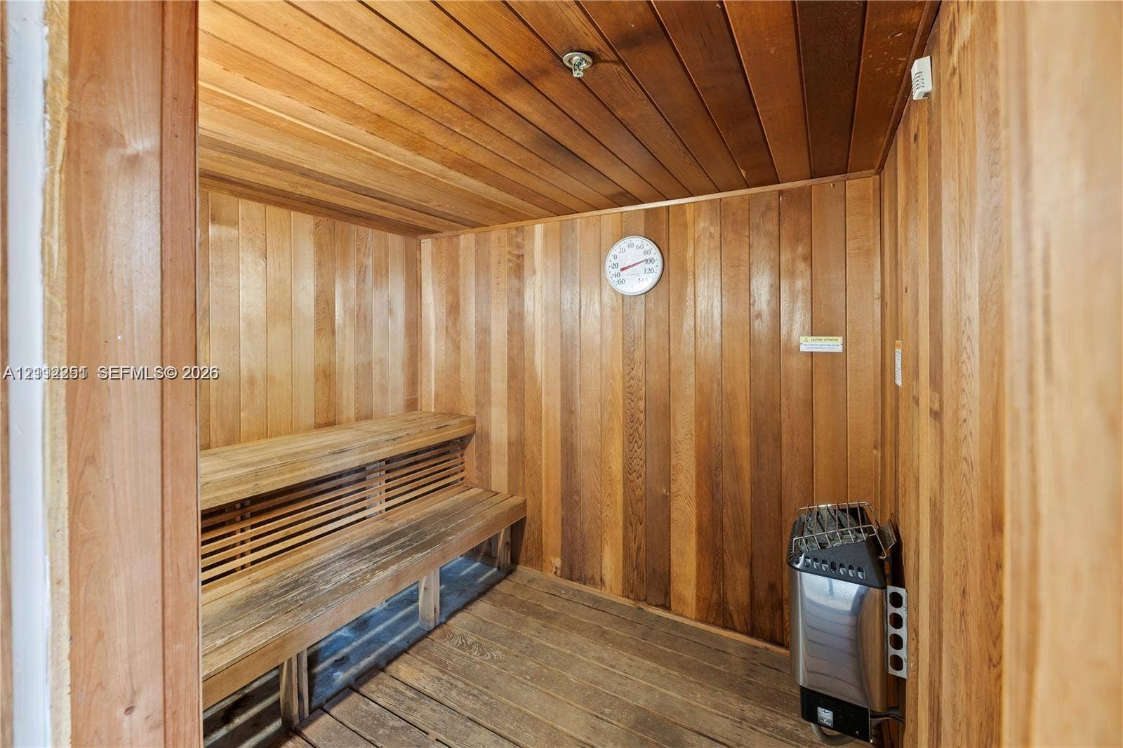 4025 N Federal Highway, #226C, Oakland Park, FL 33308 Sauna featuring wood-plank walls and ceiling, slatted wood bench seating, and an integrated heating unit