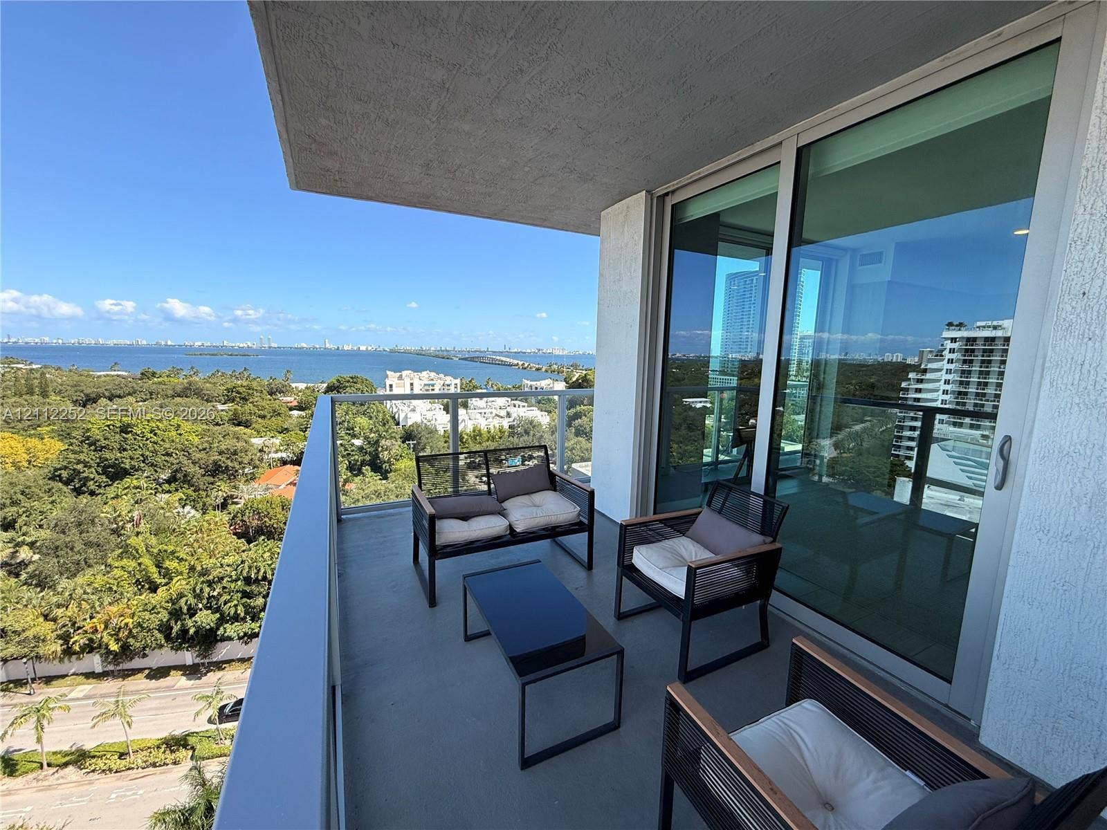 3900 Biscayne Boulevard, #N-1113, Miami, FL 33137 Private balcony featuring a glass-panel railing, concrete flooring, and full-height sliding glass doors