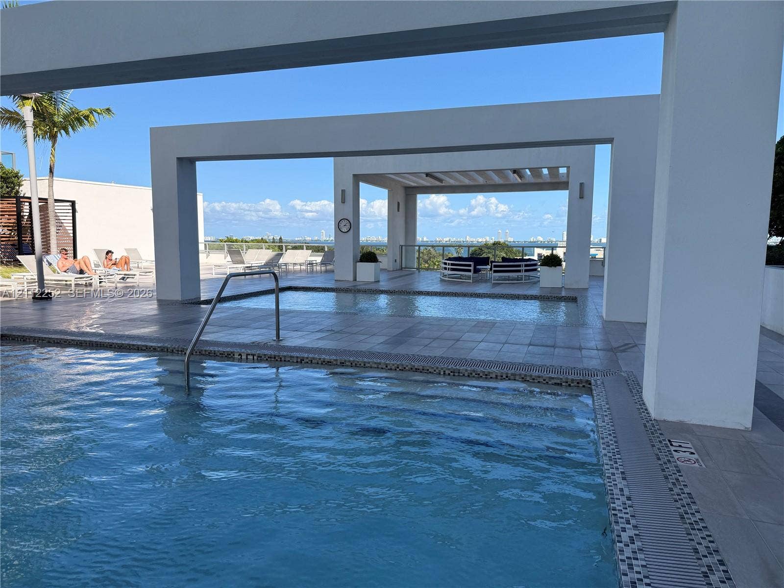 3900 Biscayne Boulevard, #N-1113, Miami, FL 33137 Swimming pool with metal handrail, tiled deck, and geometric overhead structures