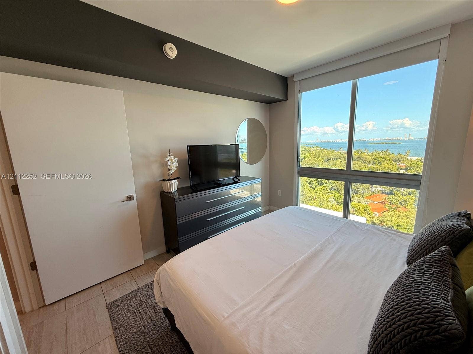 3900 Biscayne Boulevard, #N-1113, Miami, FL 33137 Floor-to-ceiling windows featuring expansive coastal and woodland scenery, tile flooring, and solid-core door