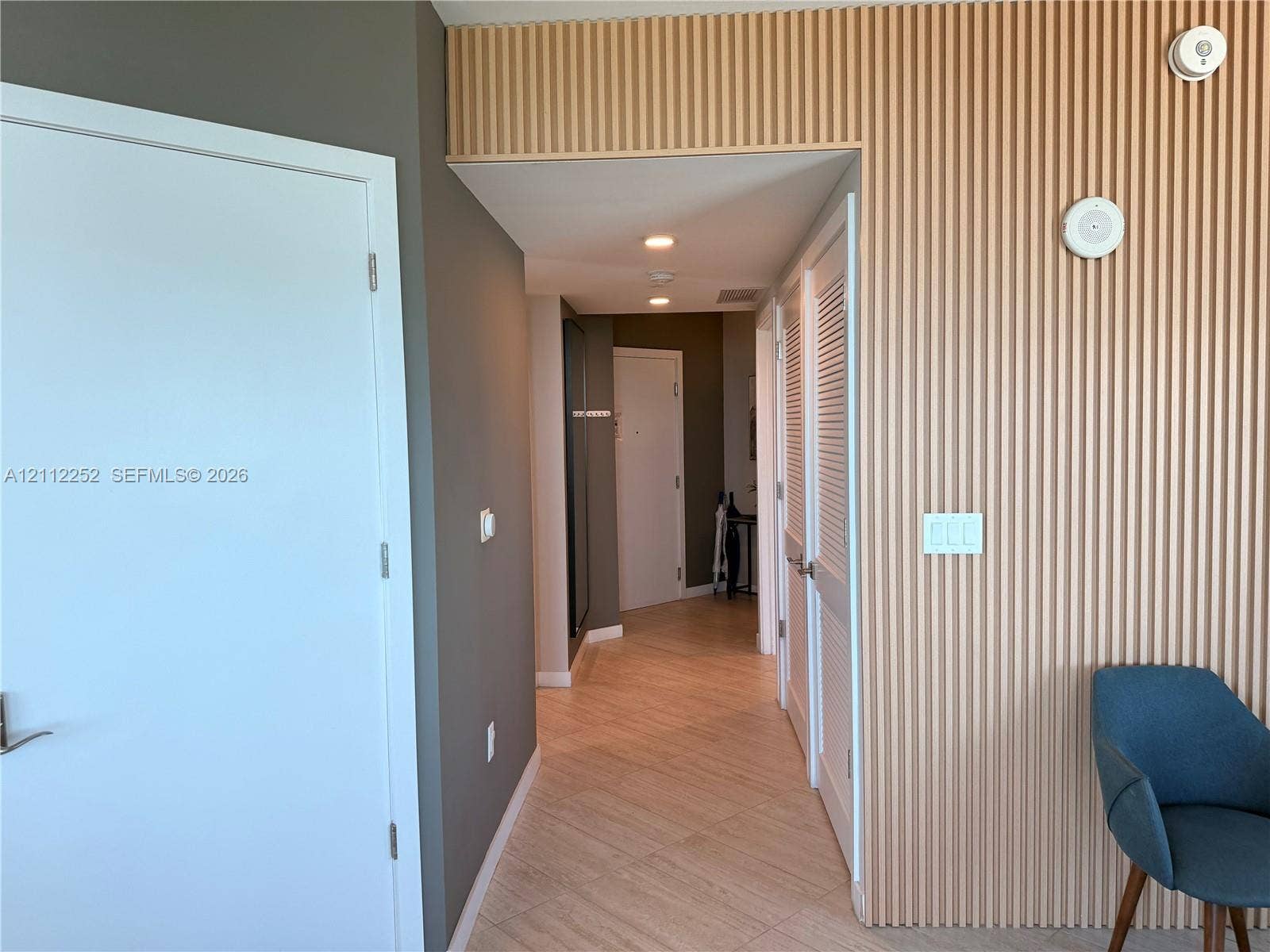 3900 Biscayne Boulevard, #N-1113, Miami, FL 33137 Vertical wood-slat wall paneling, tile flooring, recessed ceiling lighting, and louvered closet doors