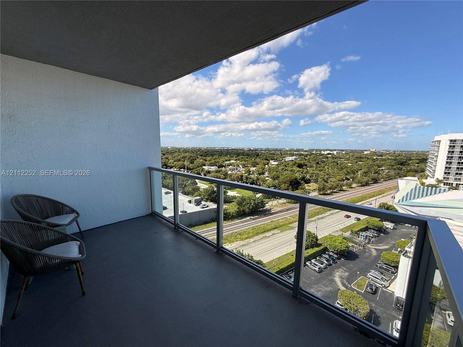 3900 Biscayne Boulevard, #N-1113, Miami, FL 33137 Covered balcony featuring concrete flooring and a glass-paneled railing