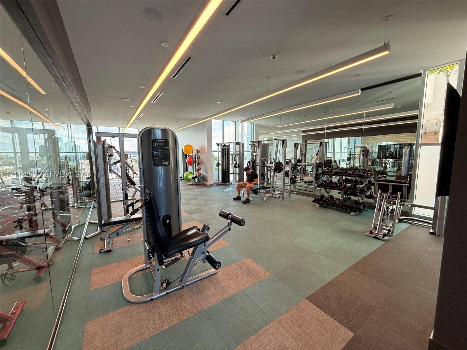 3900 Biscayne Boulevard, #N-1113, Miami, FL 33137 Fitness center featuring wall-to-wall mirrors, recessed linear LED lighting, floor-to-ceiling glass windows, and modular tile flooring