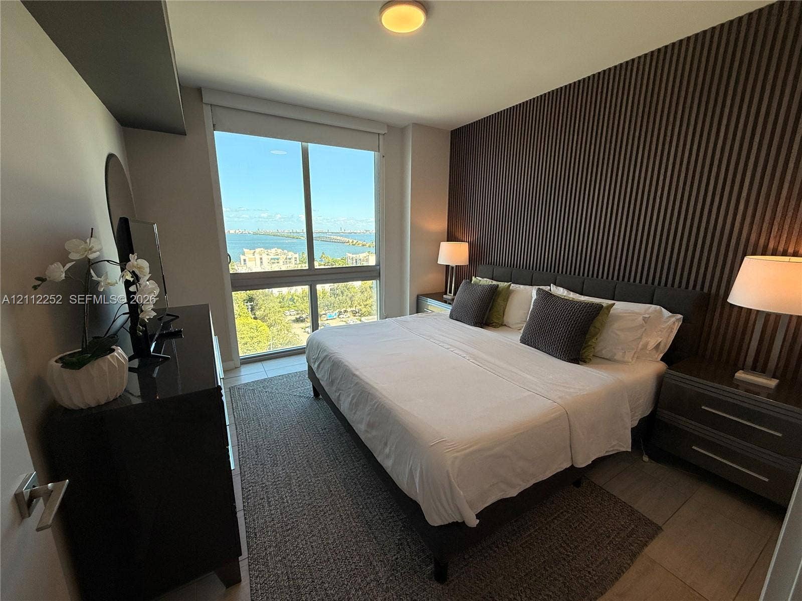 3900 Biscayne Boulevard, #N-1113, Miami, FL 33137 Floor-to-ceiling windows, dramatic vertical-slat accent wall, and ceramic tile flooring