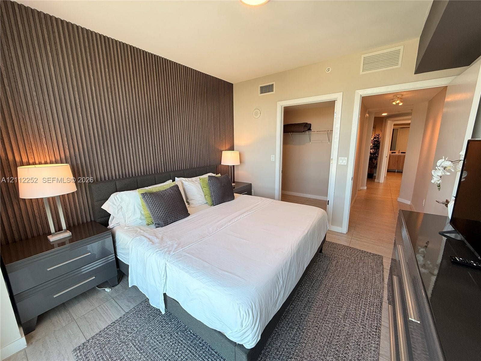 3900 Biscayne Boulevard, #N-1113, Miami, FL 33137 Textured vertical wall paneling, tile flooring, and a built-in reach-in closet