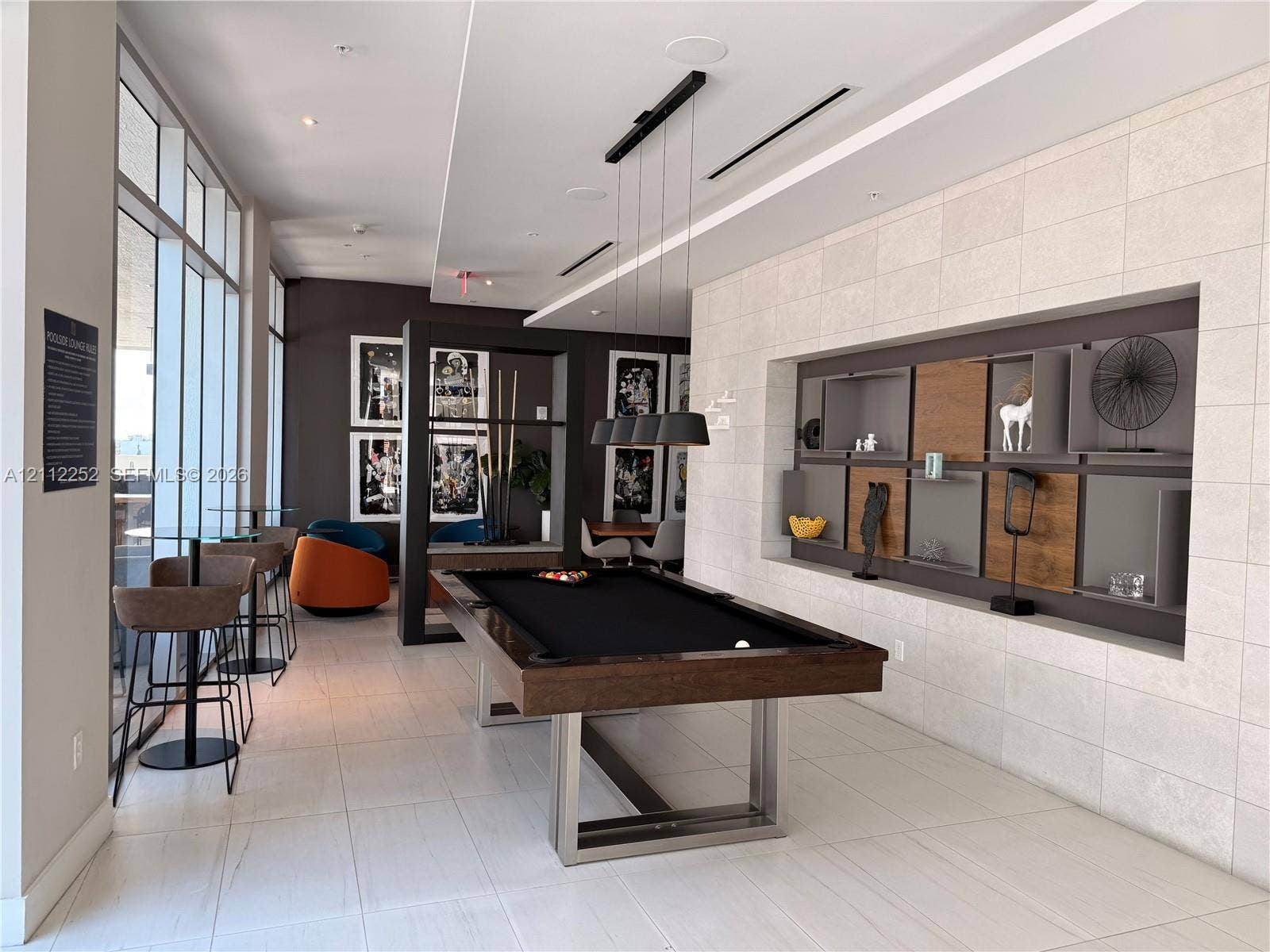3900 Biscayne Boulevard, #N-1113, Miami, FL 33137 Large-format tiled flooring, recessed wall shelving with integrated wood-panel inserts, floor-to-ceiling windows, and contemporary pendant lighting