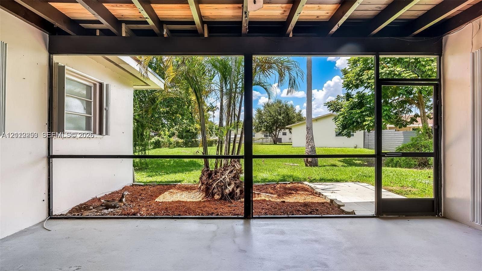 500 NW 96th Terrace, Pembroke Pines, FL 33024 Screened-in patio with concrete flooring, exposed wood-beam ceiling, and full-height mesh enclosures