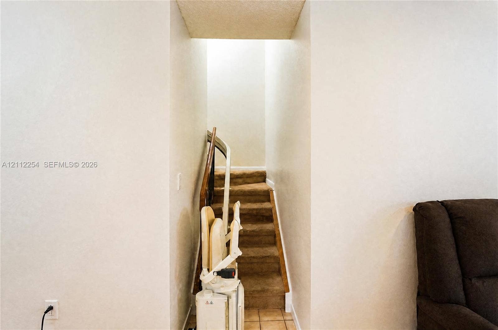 Staircase featuring wall-to-wall carpeting and a motorized stair lift