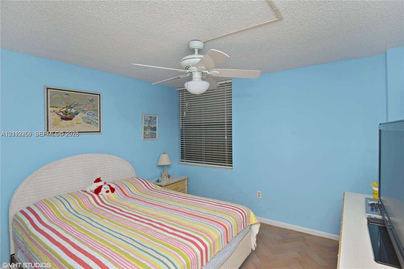 9900 S Ocean Drive, #601, Jensen Beach, FL 34957 Room featuring wood-finish herringbone flooring, a ceiling fan with integrated lighting, and horizontal window blinds