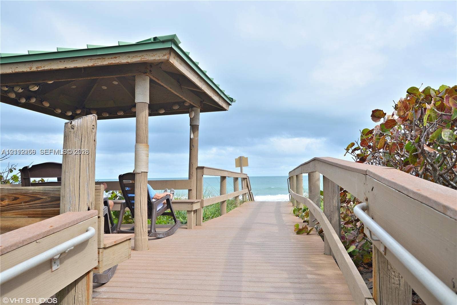 9900 S Ocean Drive, #601, Jensen Beach, FL 34957 Covered wooden gazebo featuring structural posts, a wooden boardwalk, and perimeter railings