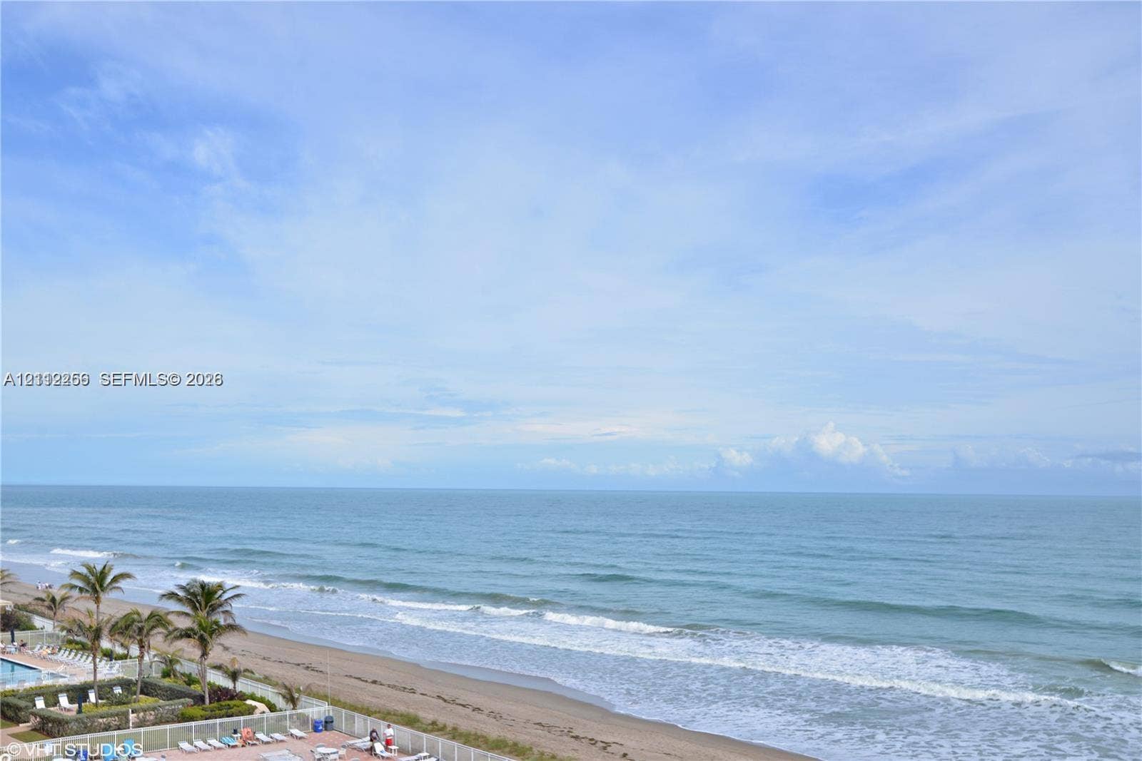 9900 S Ocean Drive, #601, Jensen Beach, FL 34957 Oceanfront perspective featuring a sandy beach, rhythmic surf, and palm trees