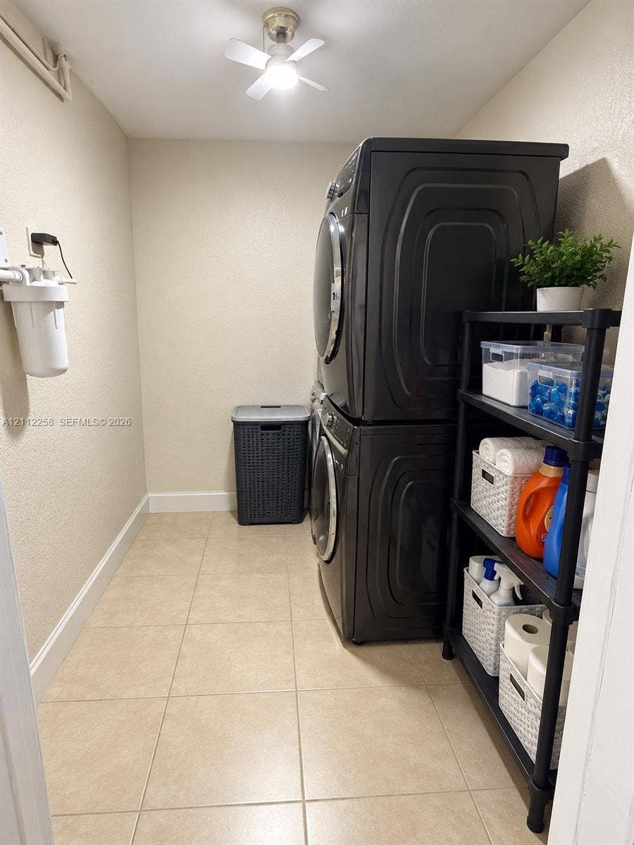 Dedicated laundry area featuring ceramic tile flooring, neutral wall tones, and a ceiling-mounted light fixture