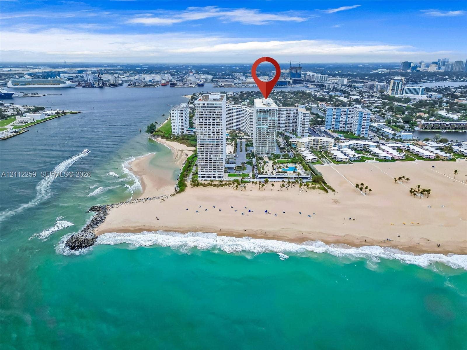 High-rise building featuring direct oceanfront access, private swimming pool, landscaped grounds, and proximity to the coastline