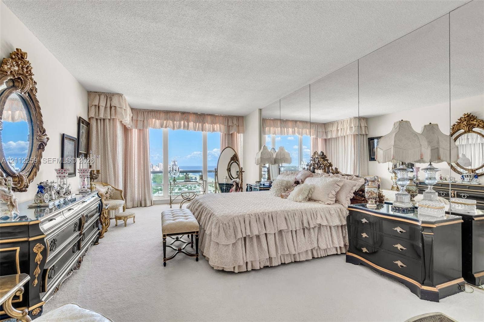 Floor-to-ceiling windows, full-wall mirrored accent, and wall-to-wall carpeting