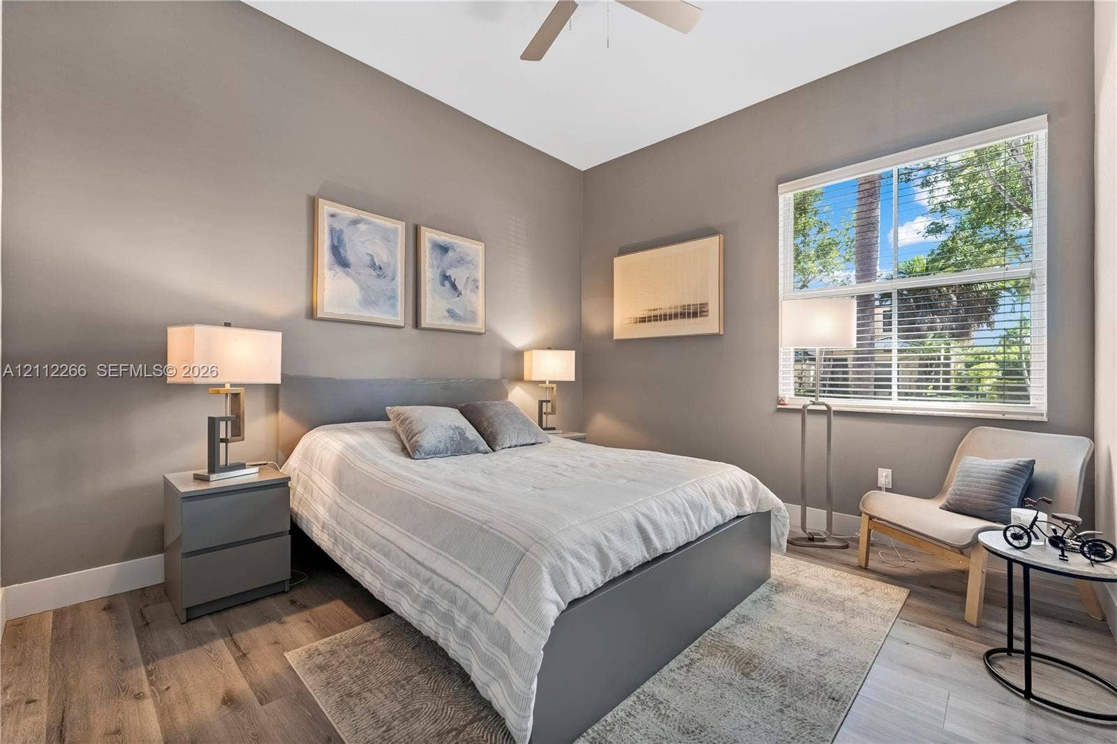 Room featuring wood-finish flooring, a neutral color palette, and a ceiling fan
