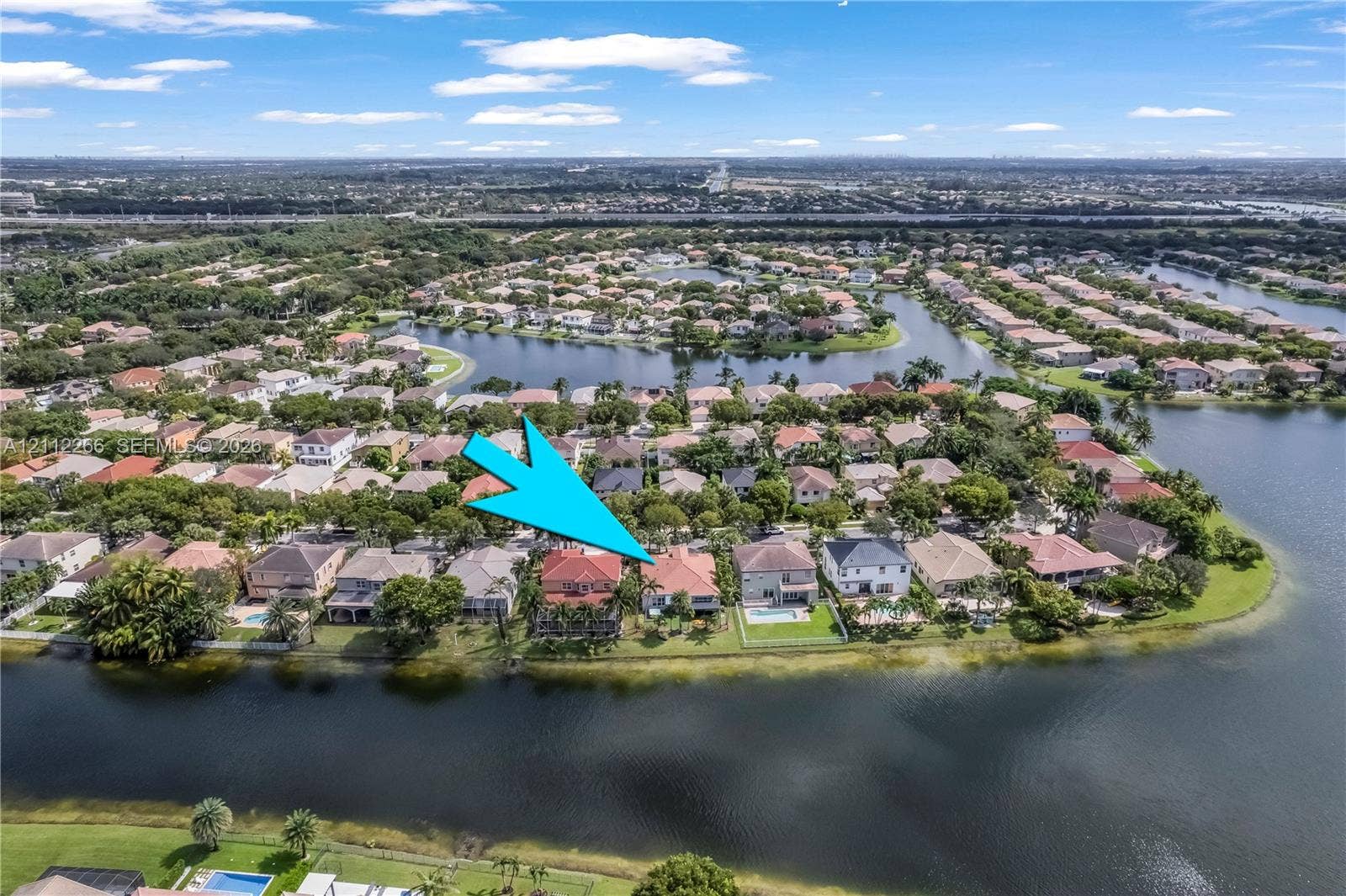 Aerial perspective featuring a waterfront property with a tile roof and a private rear swimming pool