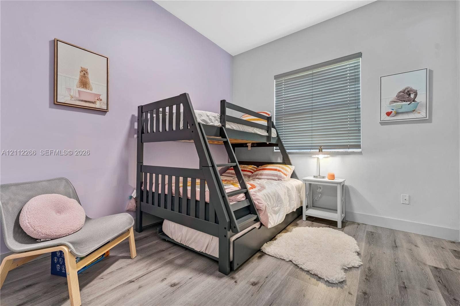 Bedroom featuring wood-finish flooring, high ceilings, and a horizontal window with adjustable blinds