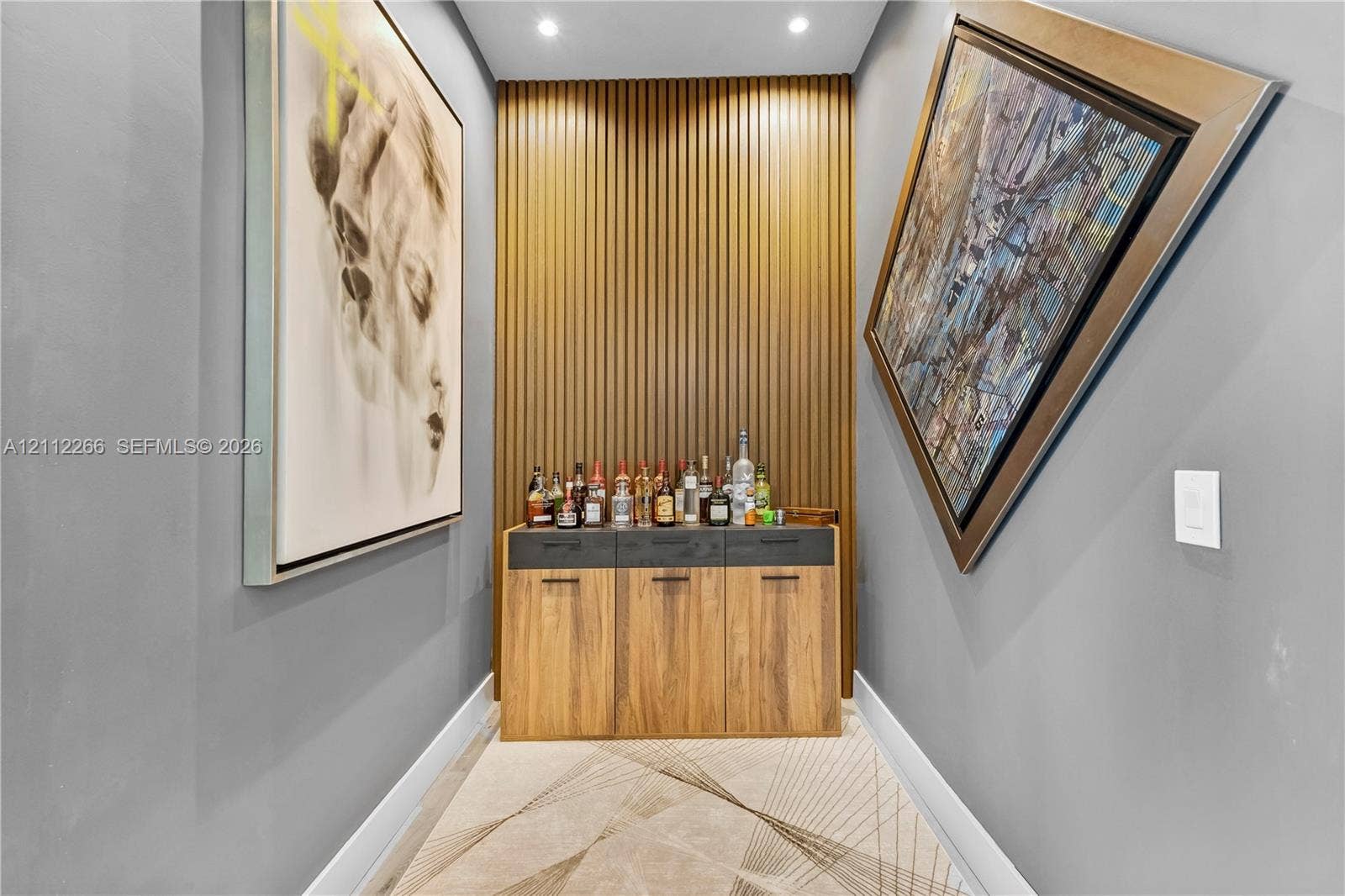 Built-in cabinetry with wood-finish doors, dark matte hardware, vertical slat wall paneling, and recessed ceiling lighting