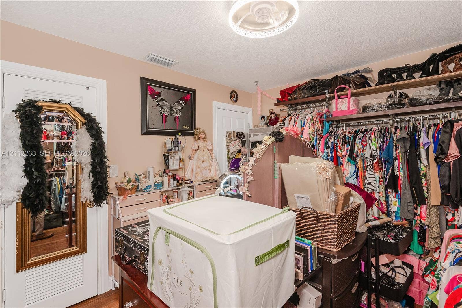 5941 SW 16th Court, Plantation, FL 33317 Storage area featuring built-in wooden shelving, a louvered-panel door, and a flush-mount circular ceiling fixture