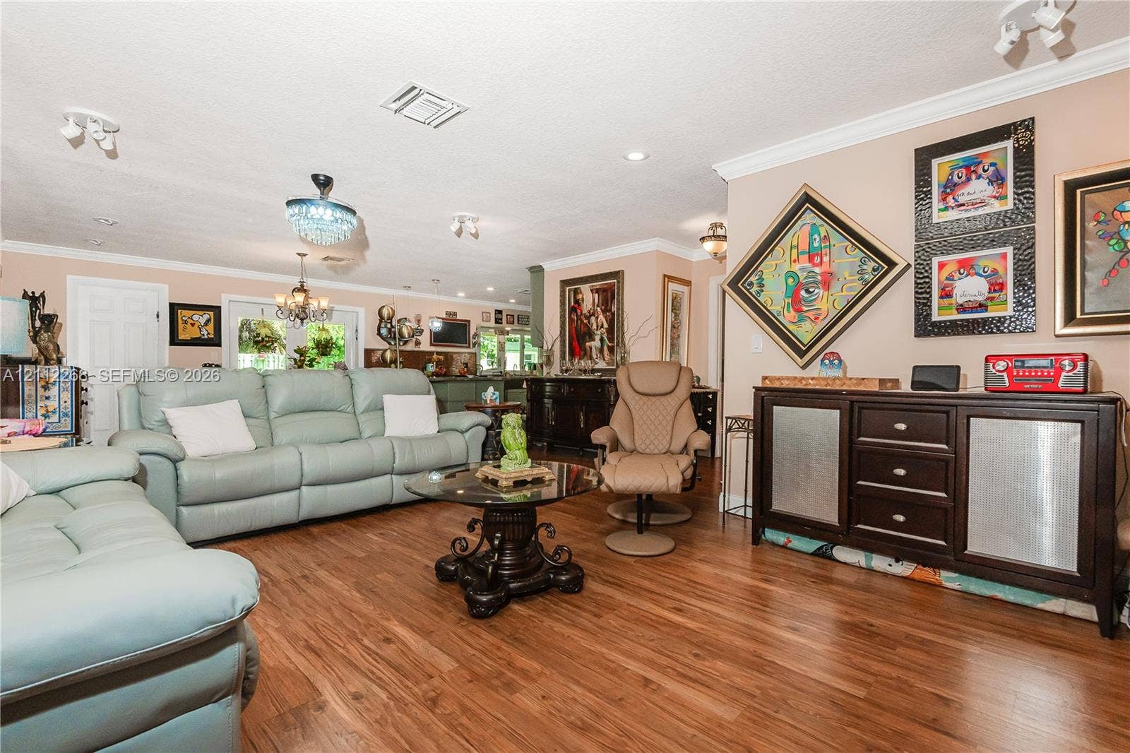 5941 SW 16th Court, Plantation, FL 33317 Living area featuring wood-finish flooring, crown molding, tiered crystal chandelier, recessed lighting, and double-door entryway