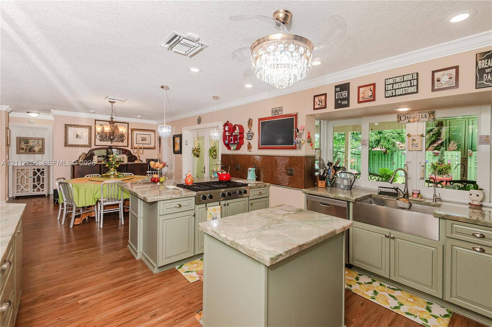 5941 SW 16th Court, Plantation, FL 33317 Kitchen featuring a large central island, custom cabinetry, a professional-style gas range, farmhouse-style sink, and stone-finish countertops