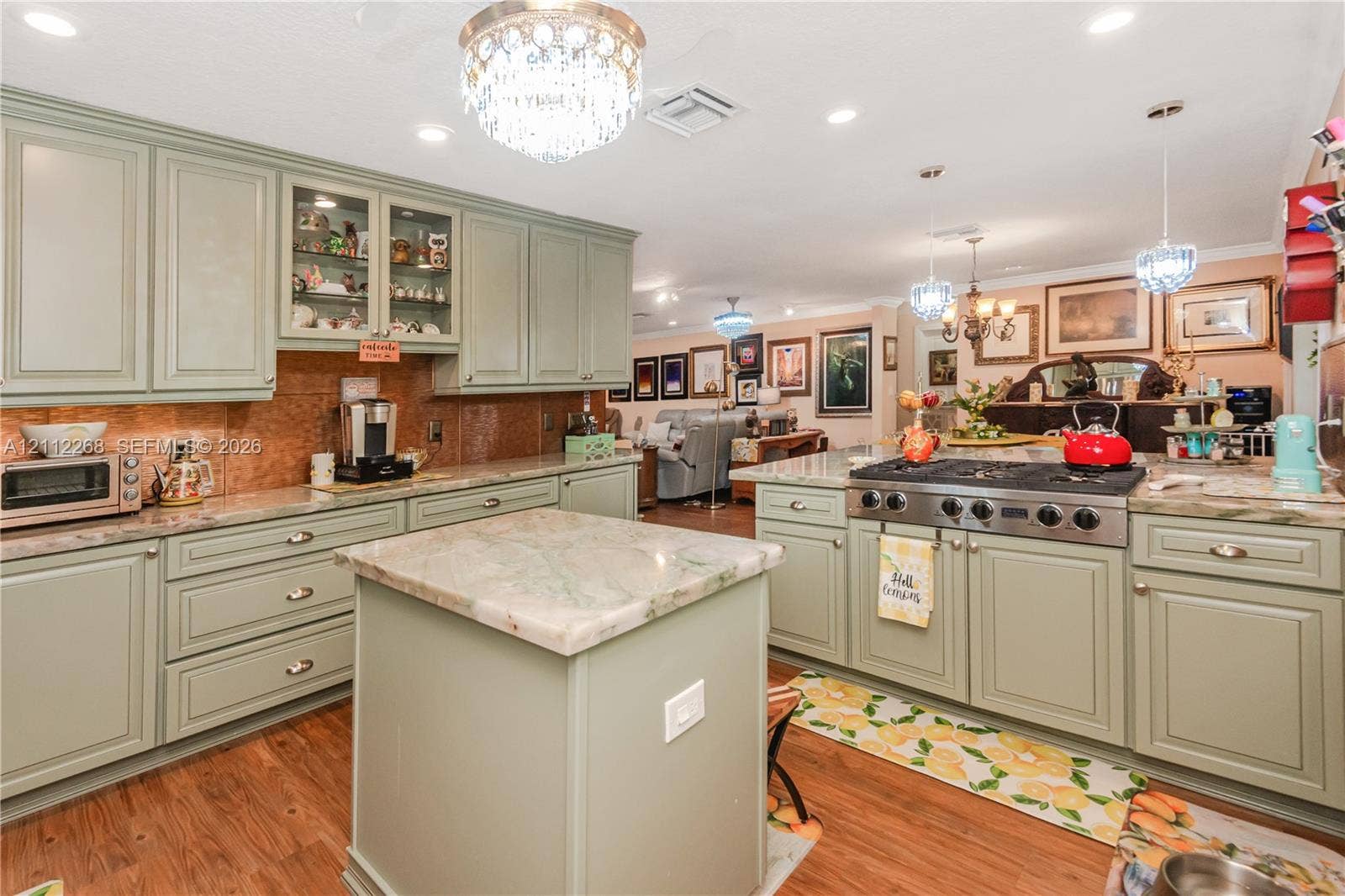 5941 SW 16th Court, Plantation, FL 33317 Kitchen featuring custom sage green cabinetry, stone-finish countertops, a central island, recessed lighting, and ornate crystal chandelier fixtures