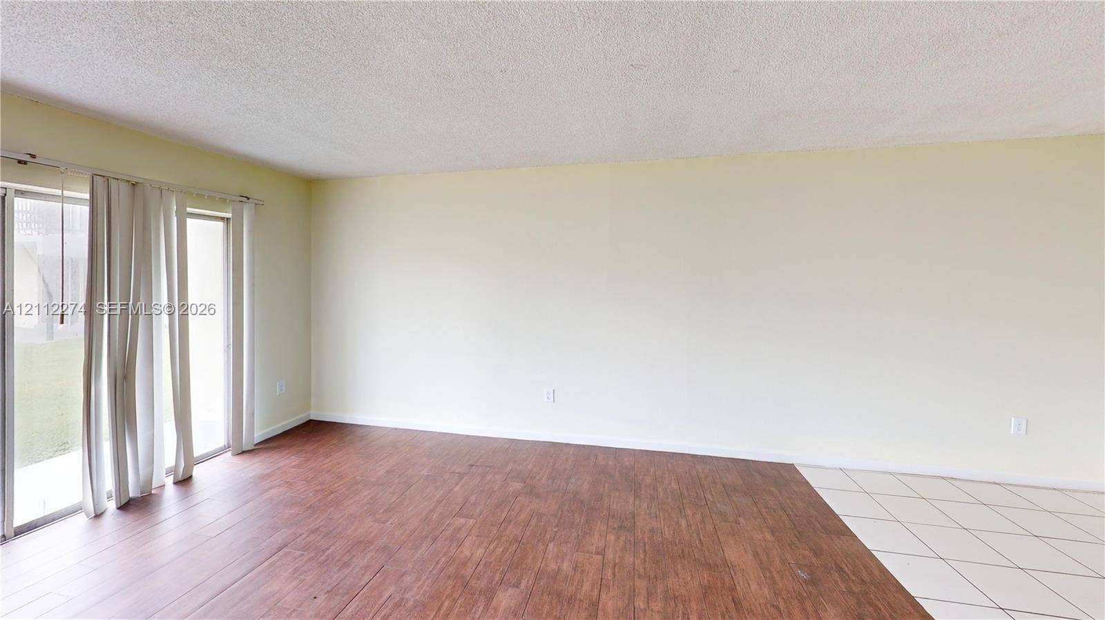 301 NW 177th Street, #141, Miami Gardens, FL 33169 Interior room featuring wood-finish flooring, white tile flooring, and large sliding glass doors