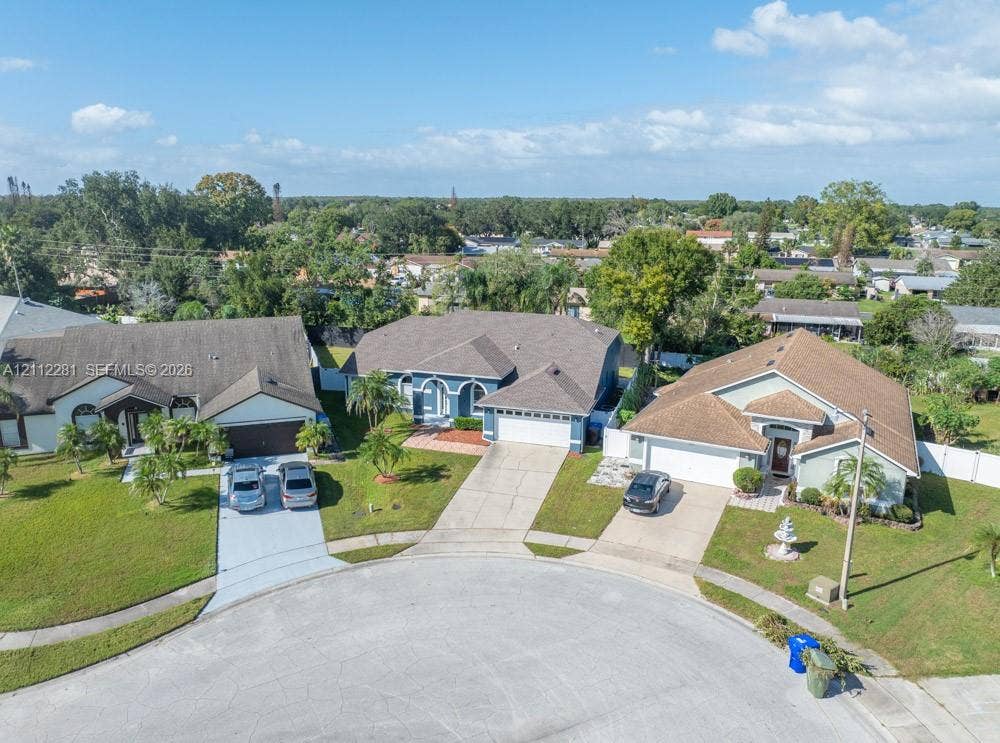 2461 Winfield, Kissimmee, FL 34743 Single-story residence featuring a multi-gable roofline, a concrete driveway, a two-car garage, and established landscaping situated in a cul-de-sac