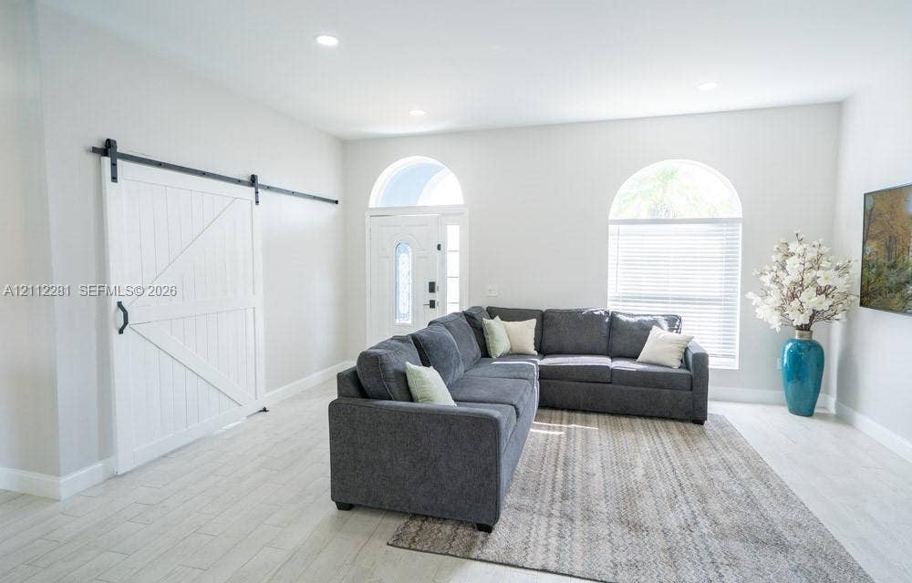 2461 Winfield, Kissimmee, FL 34743 White sliding barn door, arch-top windows, light-tone tile flooring, and recessed ceiling lighting