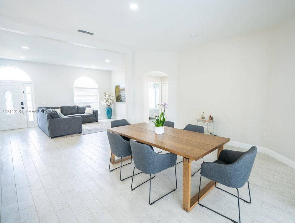 2461 Winfield, Kissimmee, FL 34743 Open-concept interior featuring wood-finish tile flooring, arched windows, recessed lighting, and a prominent arched entryway