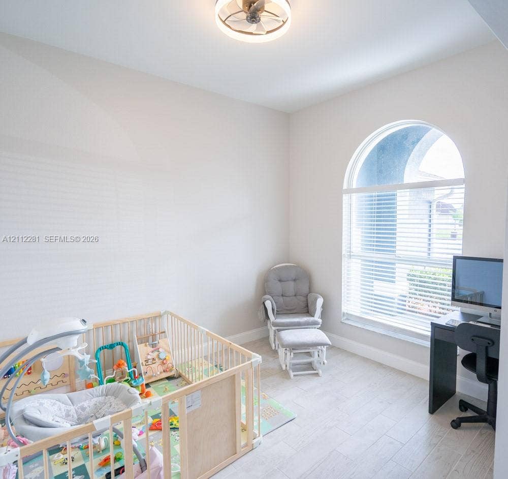 2461 Winfield, Kissimmee, FL 34743 Arched window with light-toned wood-finish flooring and integrated circular ceiling fan fixture