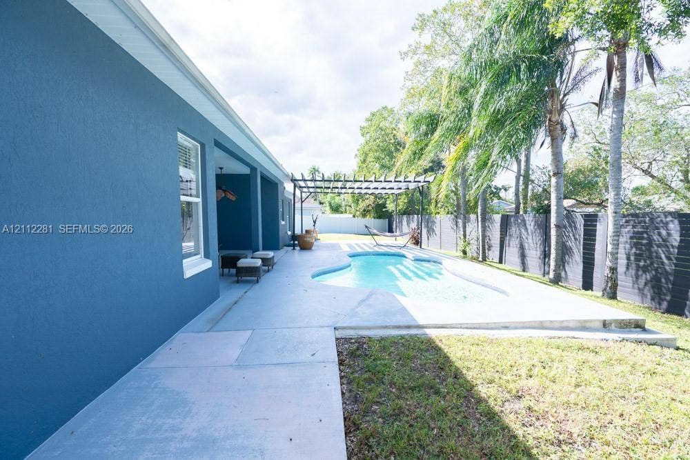 2461 Winfield, Kissimmee, FL 34743 Private backyard featuring a swimming pool, concrete patio, wooden pergola, and perimeter fencing