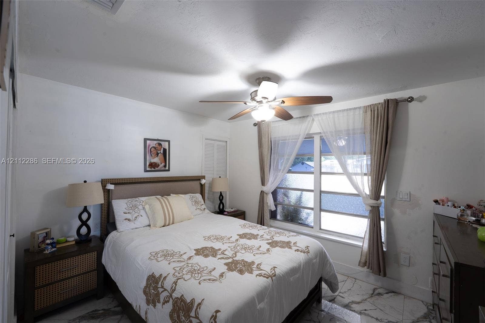 Large-format tile flooring, multi-pane window, and integrated ceiling fan with light fixture