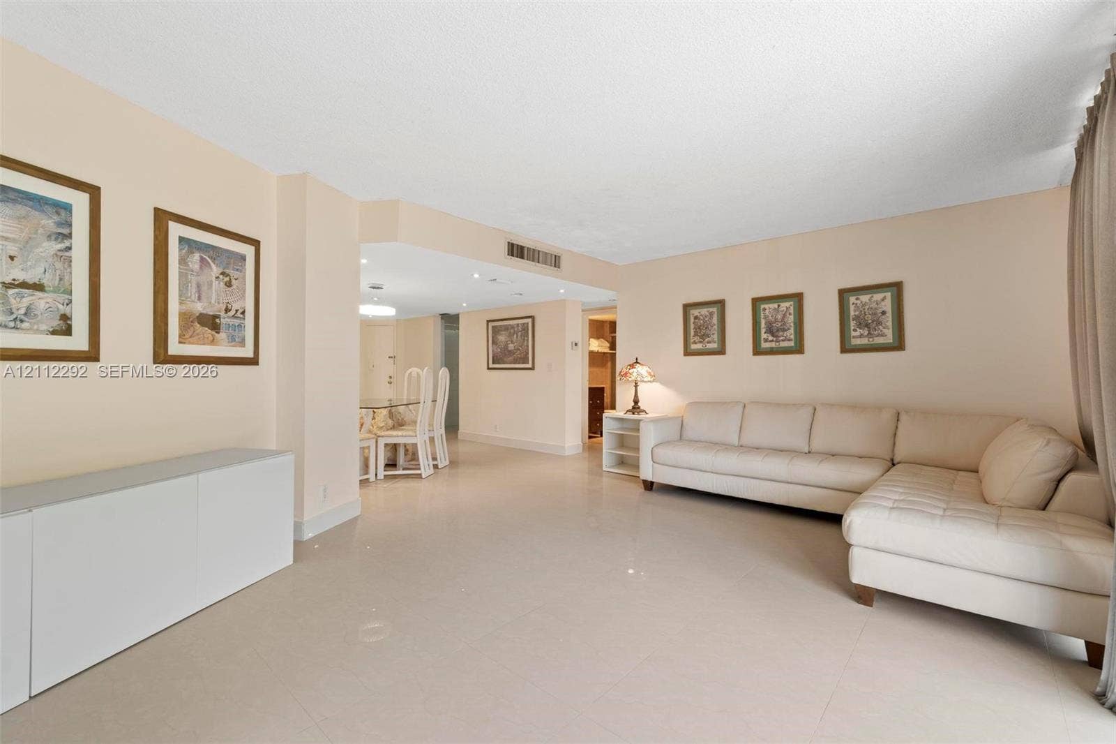 Open-concept interior featuring large-format tile flooring, smooth ceiling finishes, and recessed lighting