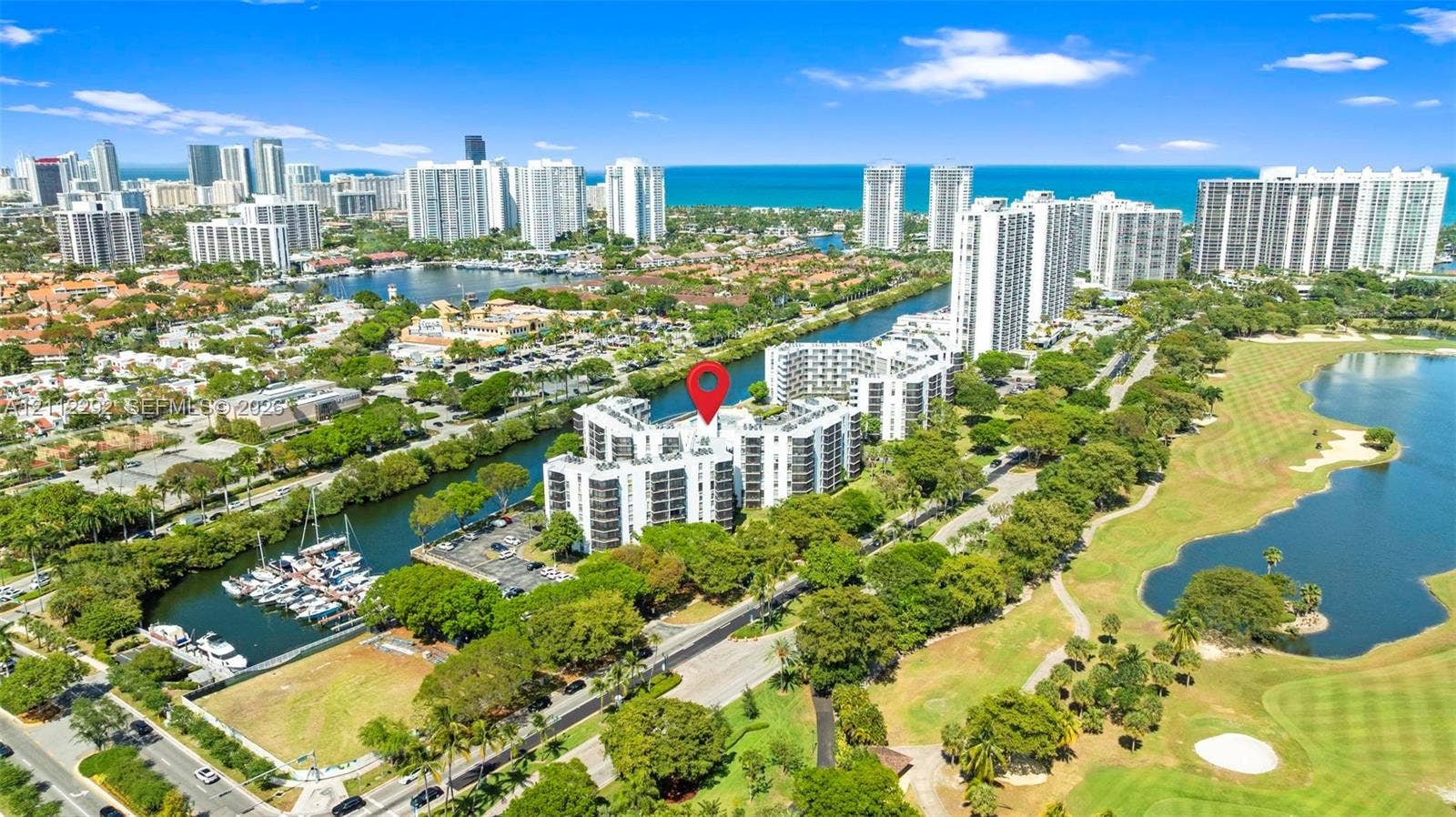 Mid-rise residential building situated on a waterfront lot featuring marina access and proximity to local golf course grounds
