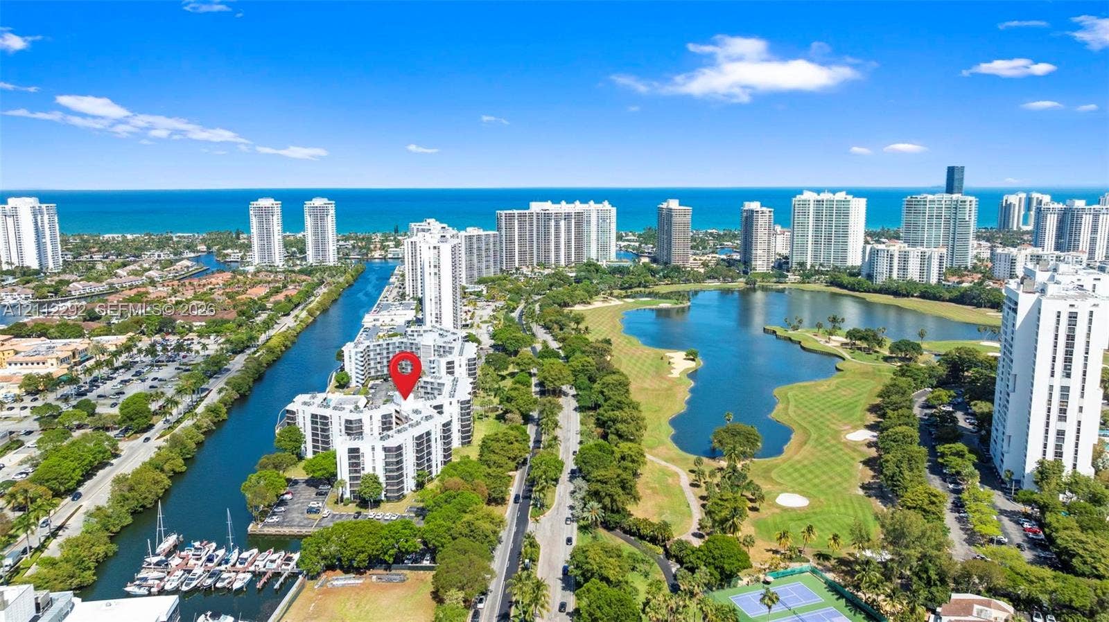 Aerial perspective featuring proximity to the Atlantic coastline, waterfront canal access, boat slips, and an expansive golf course