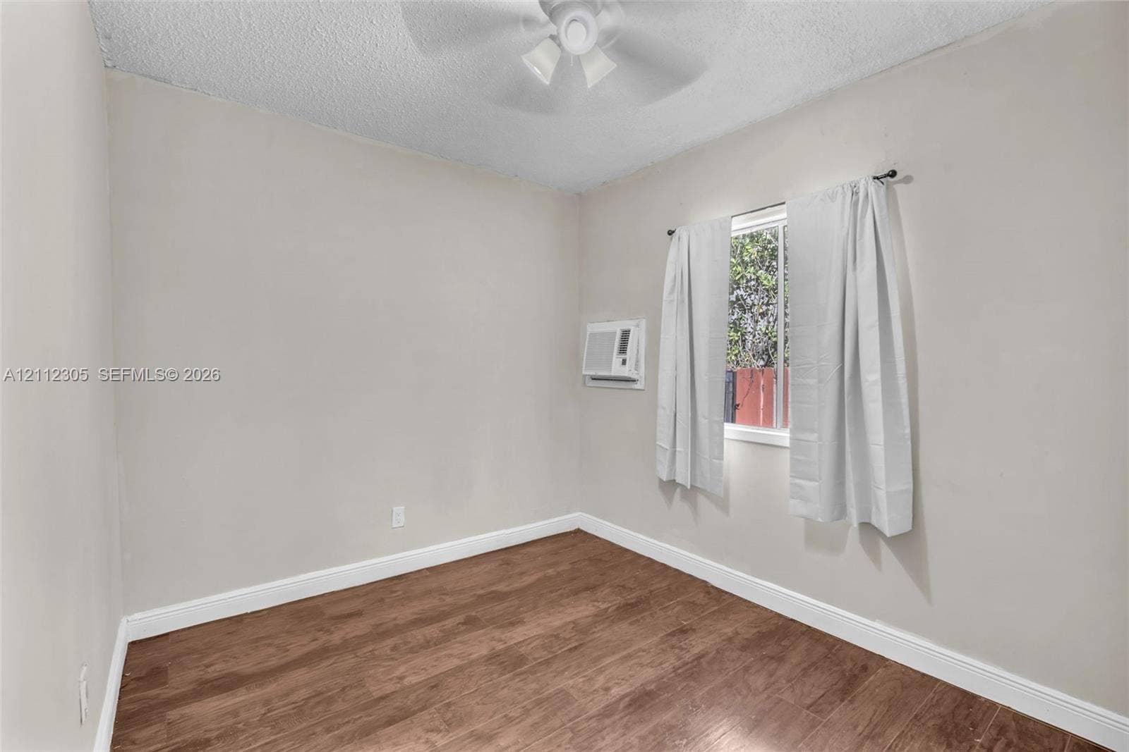 1008 N 18th Court, Hollywood, FL 33020 Room featuring wood-finish flooring, a ceiling fan, and a wall-mounted cooling unit