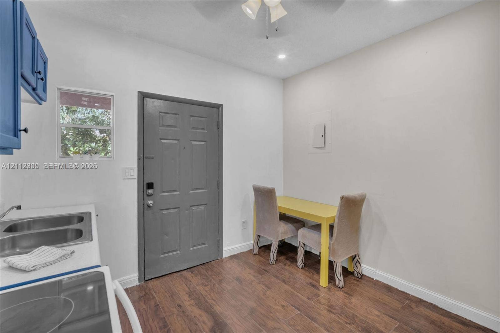 1008 N 18th Court, Hollywood, FL 33020 Interior space featuring wood-finish flooring, a double-basin stainless steel sink, solid-core entry door, and ceiling-mounted lighting