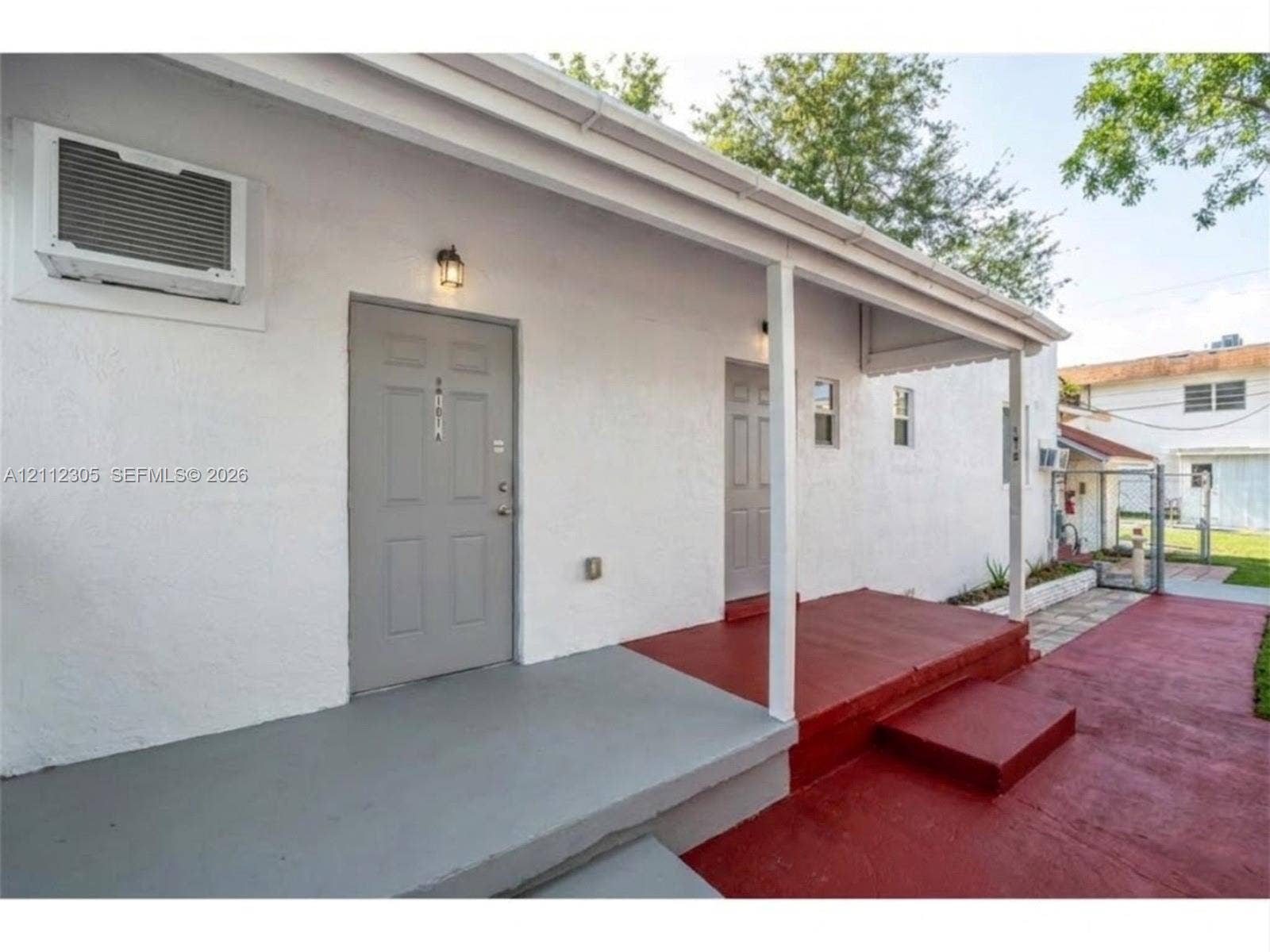 1008 N 18th Court, Hollywood, FL 33020 AI enhanced: porch cleaned and repainted, wall AC unit replaced, clutter removed. Possible improvement, not the current condition. The unaltered original is the previous photo.