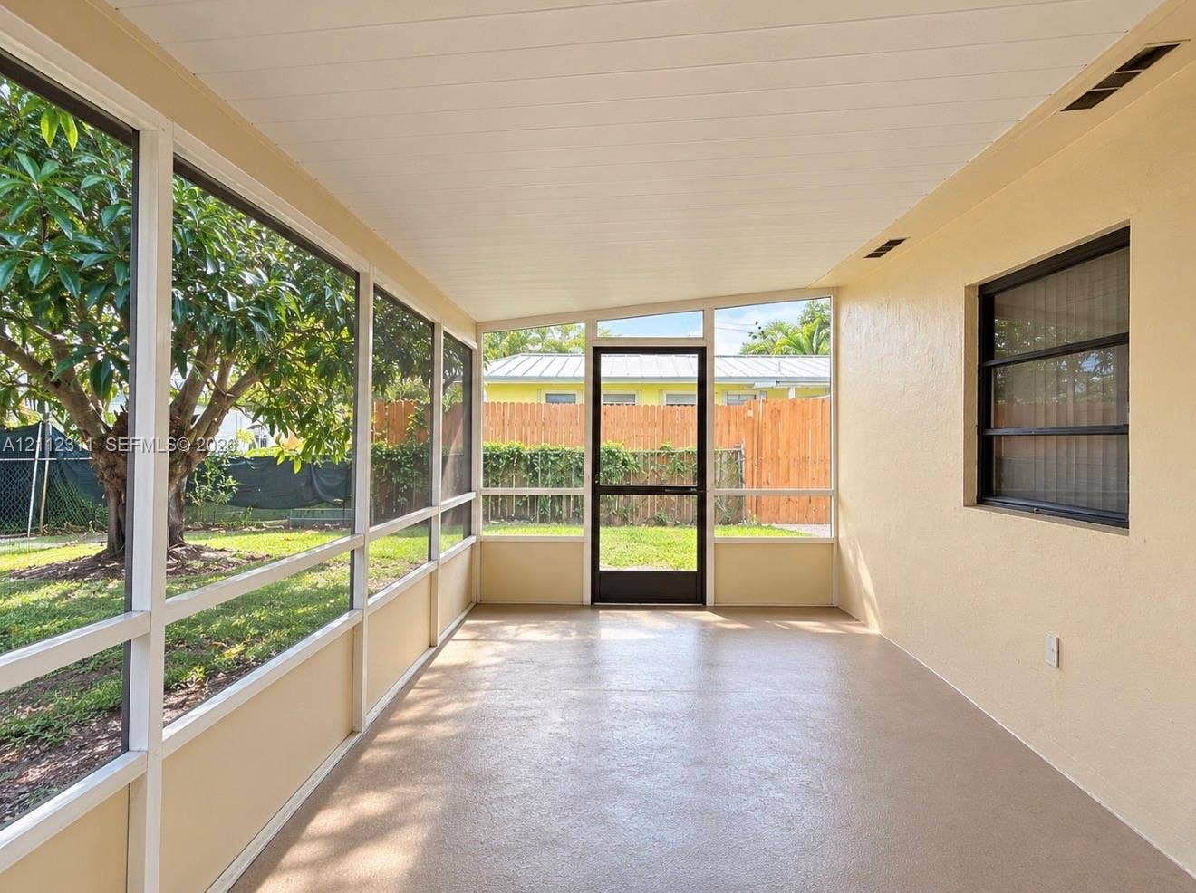 390 NW 49th Avenue, Plantation, FL 33317 Screened-in porch featuring a textured concrete floor, paneled ceiling, and full-height window screening