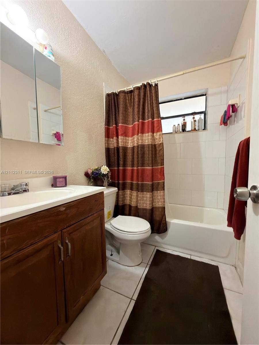 390 NW 49th Avenue, Plantation, FL 33317 Full bathroom featuring a wood-finish vanity with an integrated sink, a mirrored medicine cabinet, and a tub-shower combination with white wall tile
