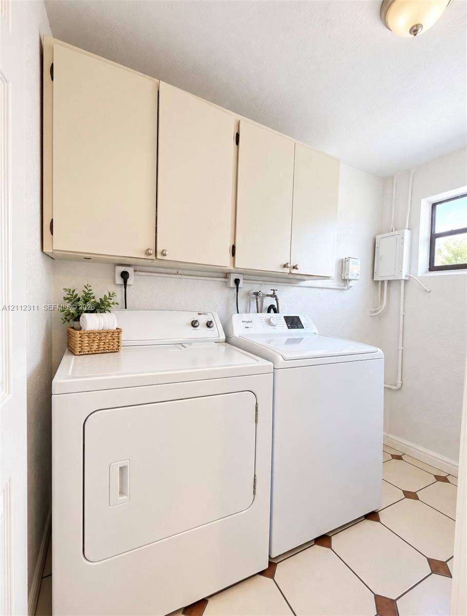 390 NW 49th Avenue, Plantation, FL 33317 Utility room featuring white flat-panel upper cabinetry, tile flooring with diamond accents, and a fixed window