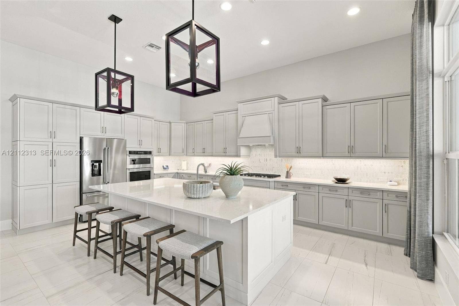 Kitchen featuring shaker-style cabinetry, quartz countertops, a central island, recessed lighting, and geometric pendant fixtures