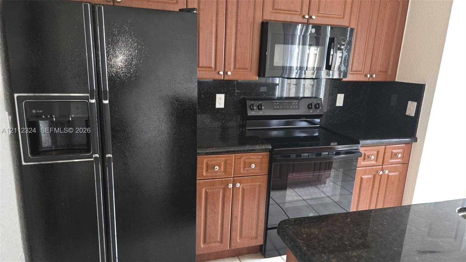 Kitchen featuring wooden cabinetry, dark stone countertops, and black appliance suite including a built-in microwave and range
