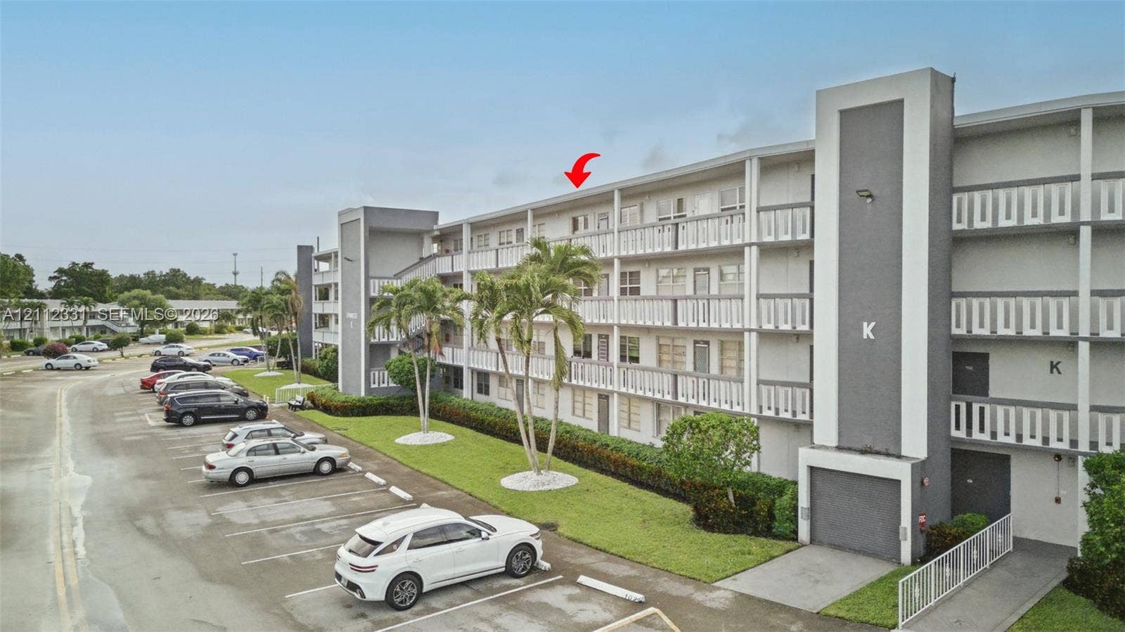 4025 Upminster K, #4025, Deerfield Beach, FL 33442 Mid-rise building featuring a concrete exterior with multi-level covered walkways and designated surface parking