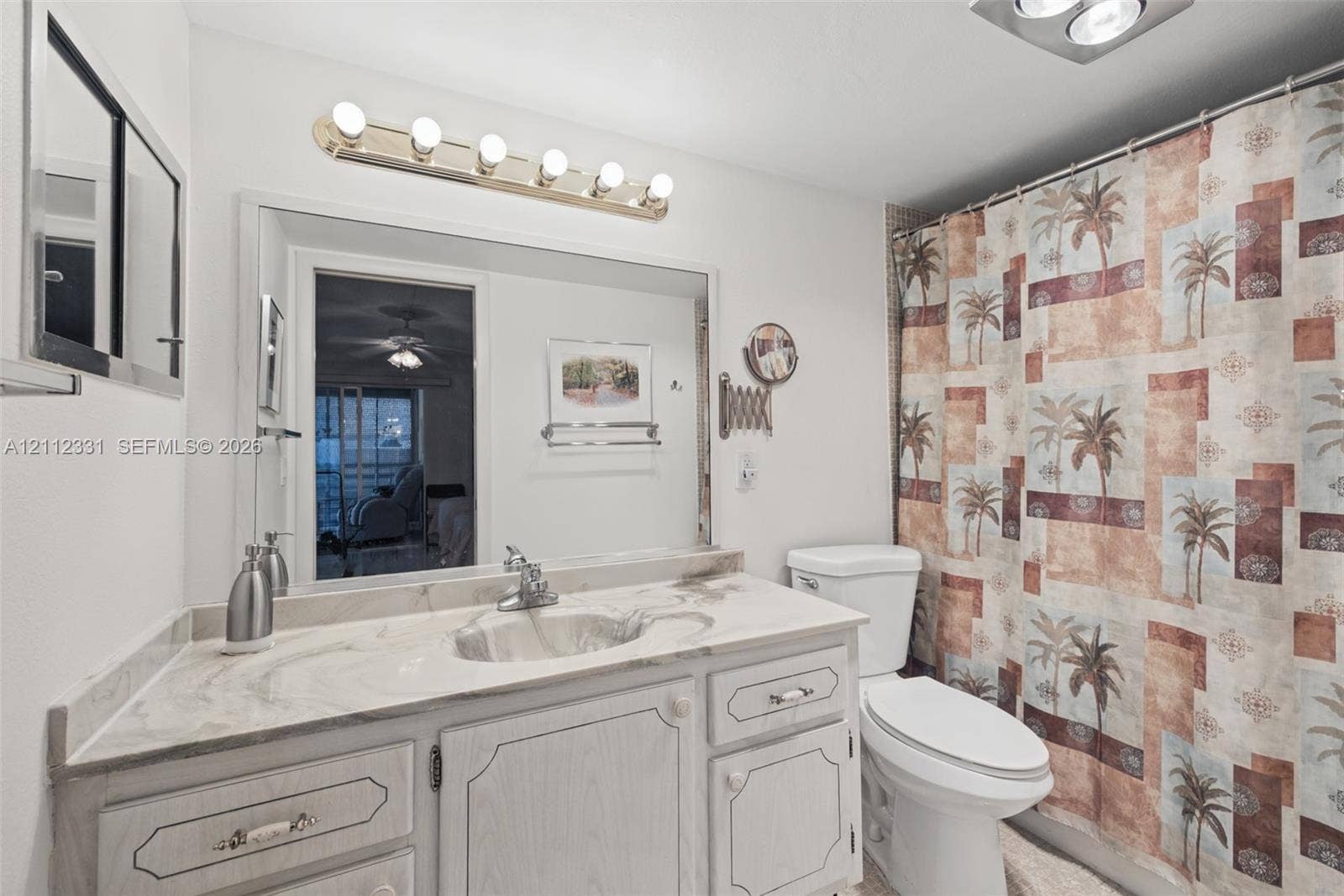 4025 Upminster K, #4025, Deerfield Beach, FL 33442 Bathroom featuring a vanity with integrated sink and countertop, large wall-mounted mirror, multi-bulb vanity light fixture, and two-piece toilet