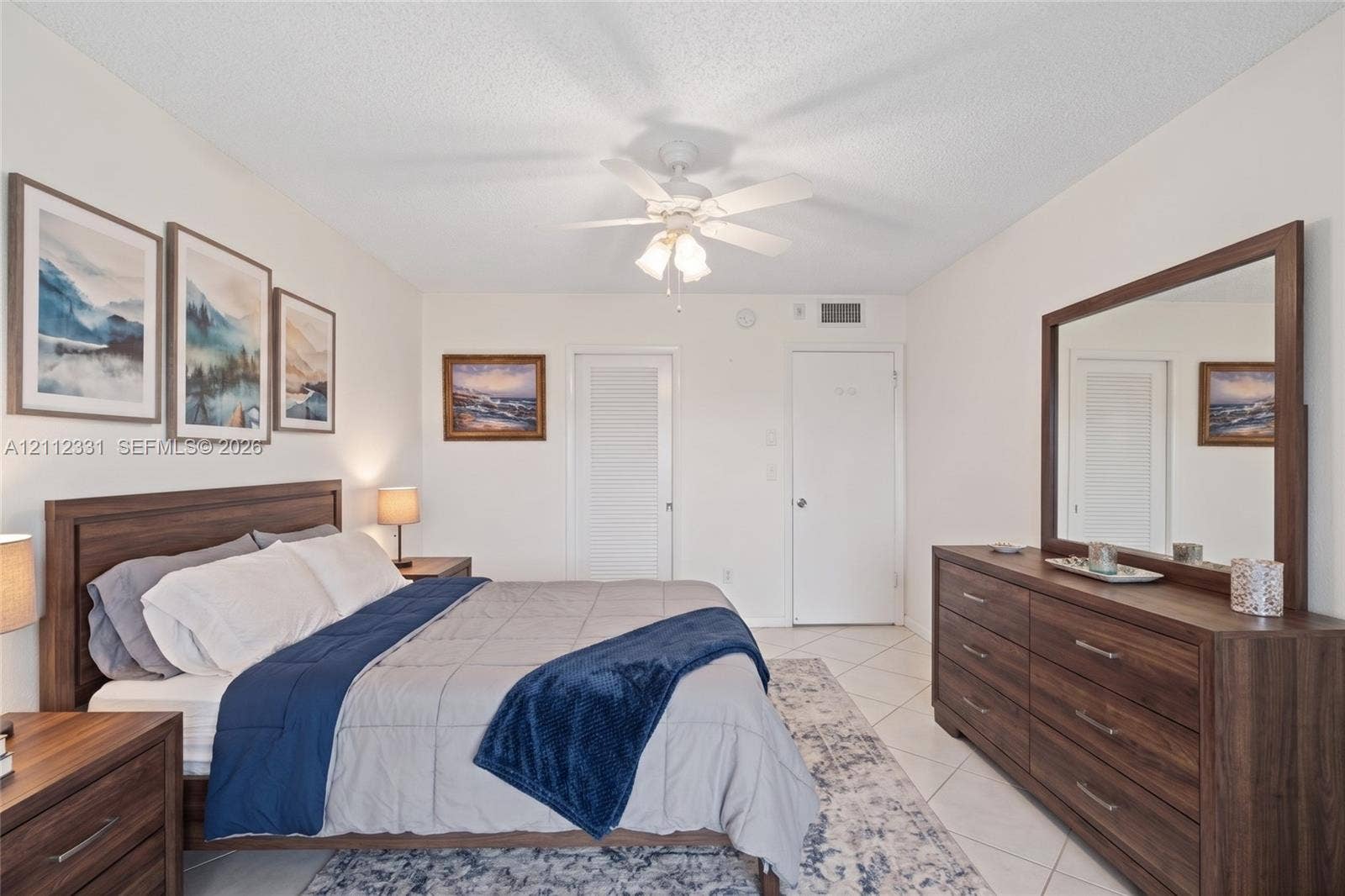 4025 Upminster K, #4025, Deerfield Beach, FL 33442 Bedroom featuring white walls, white tile flooring, and a white ceiling fan with integrated lighting